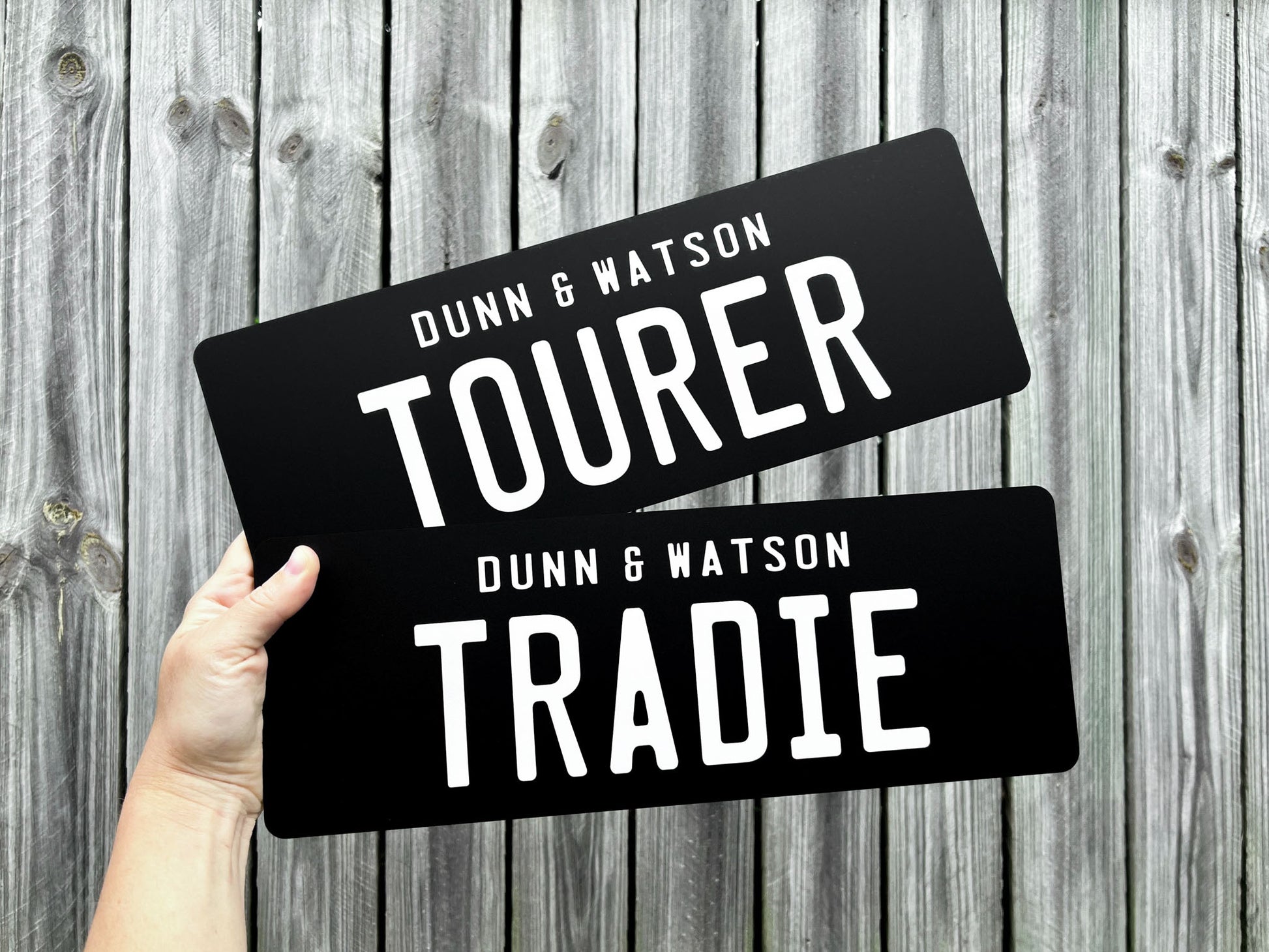 Two black acrylic plates for 'Dunn & Watson' with the text 'TOURER' & 'TRADIE' in white text.
