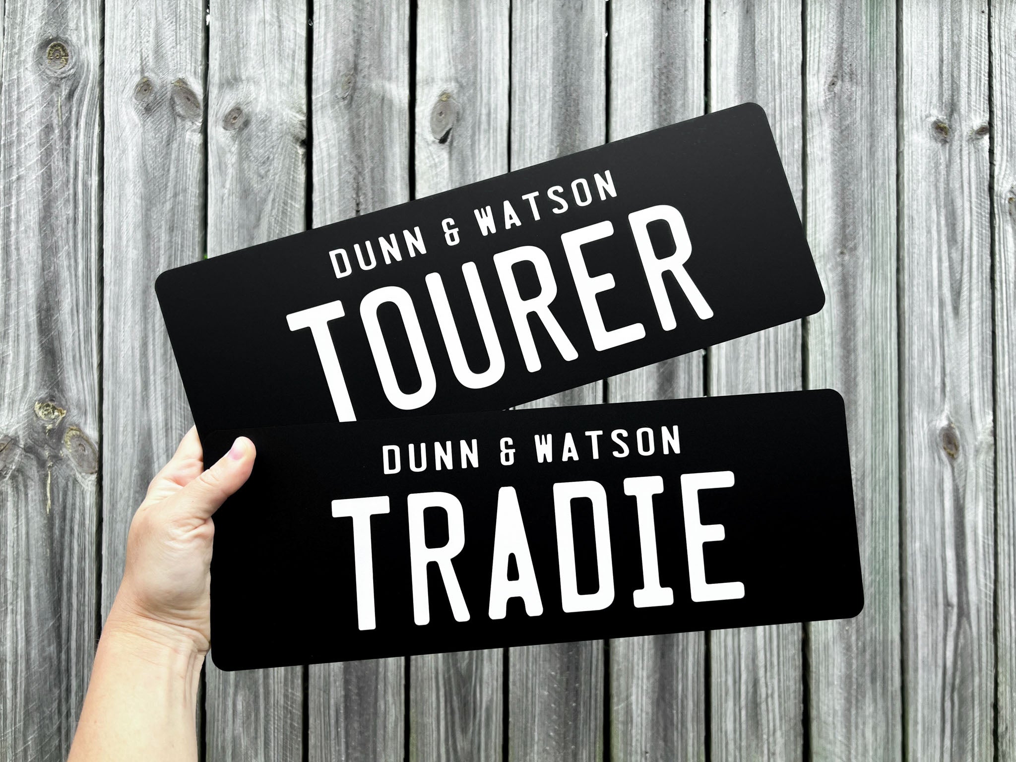 Two black acrylic plates for 'Dunn & Watson' with the text 'TOURER' & 'TRADIE' in white text.