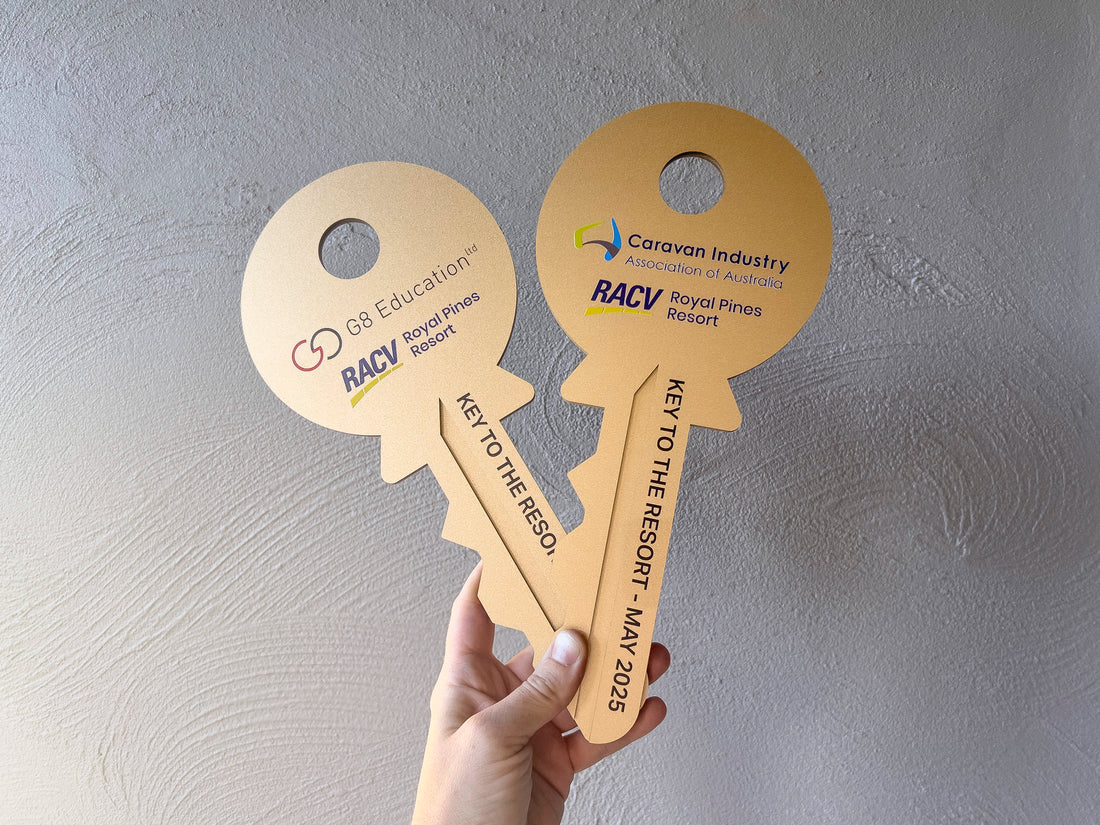 Two metallic gold keys for 'RACV Royal Pines Resort'.