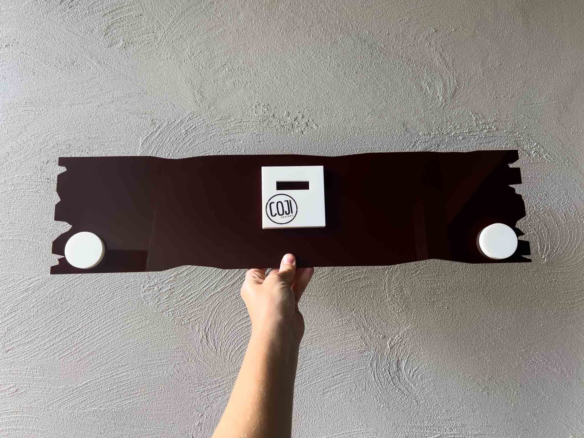 A back view of the Castaway acrylic sign with a custom wall hanger.