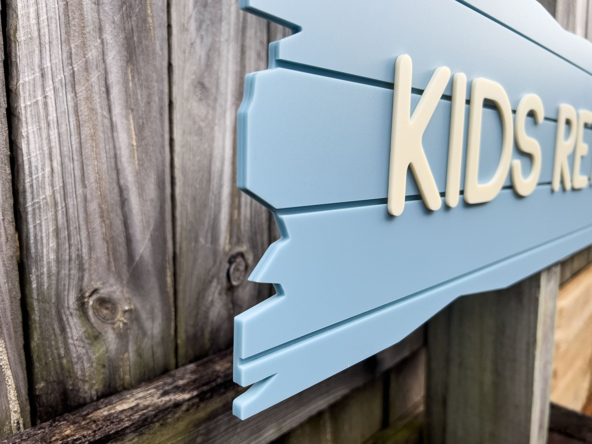 A side view of a coastal blue Castaway plank sign.
