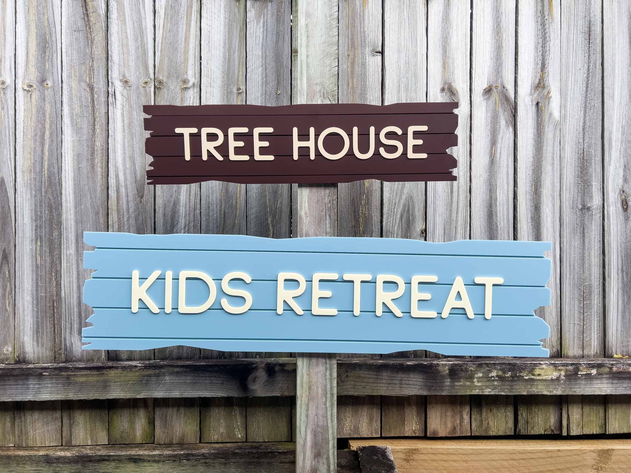 A ship wreakage style plank sign with custom text that reads 'TREE HOUSE' & 'KIDS RETREAT' in a dark brown and blue colour.