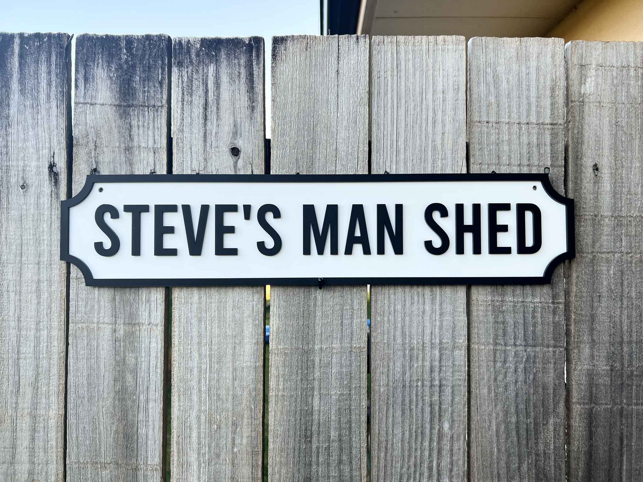 Sign reading 'Steve's Man Shed' on a wooden fence