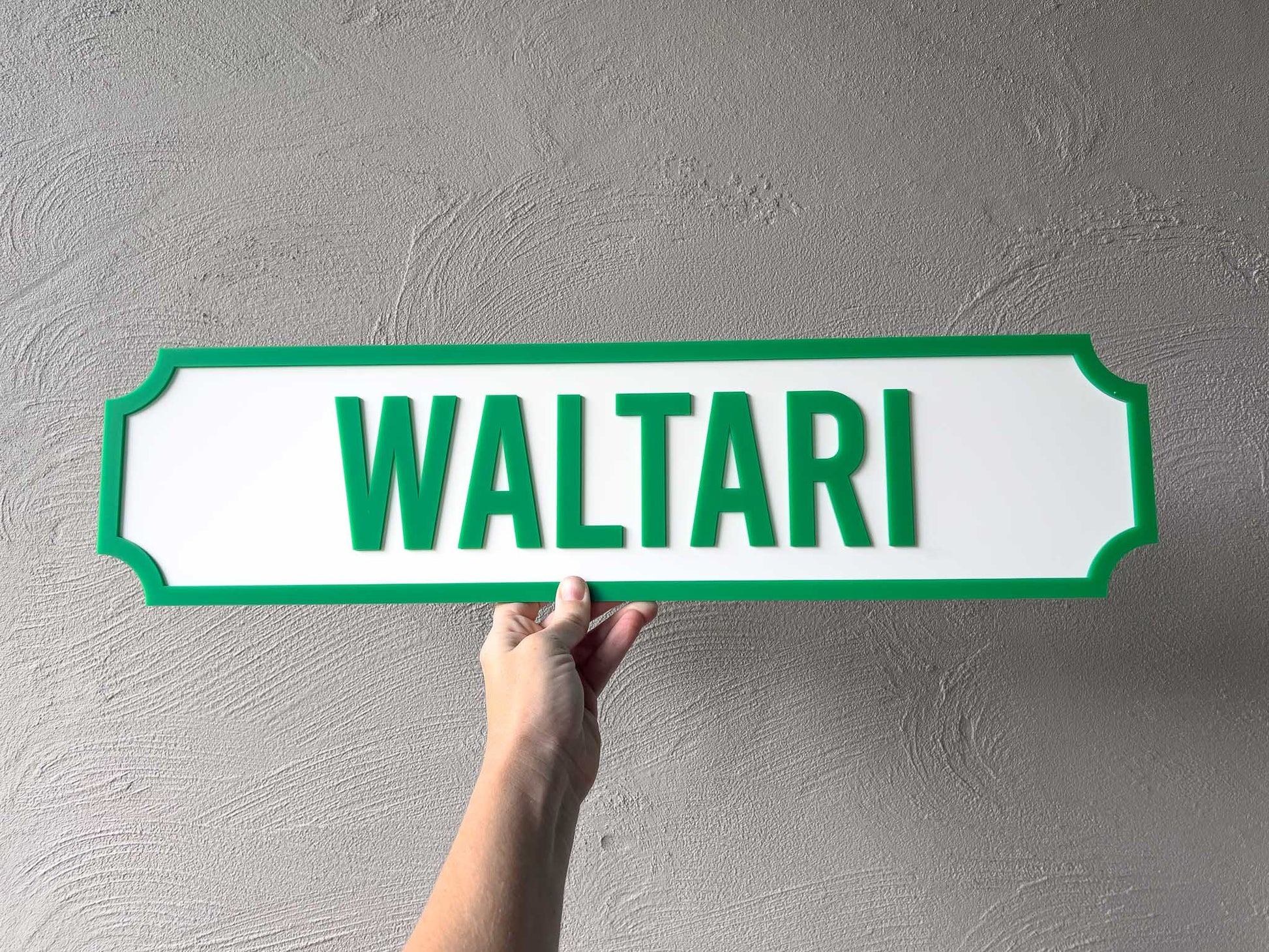 A personalised white classic-style custom text sign with a green border and the name 'WALTARI' in green letters.