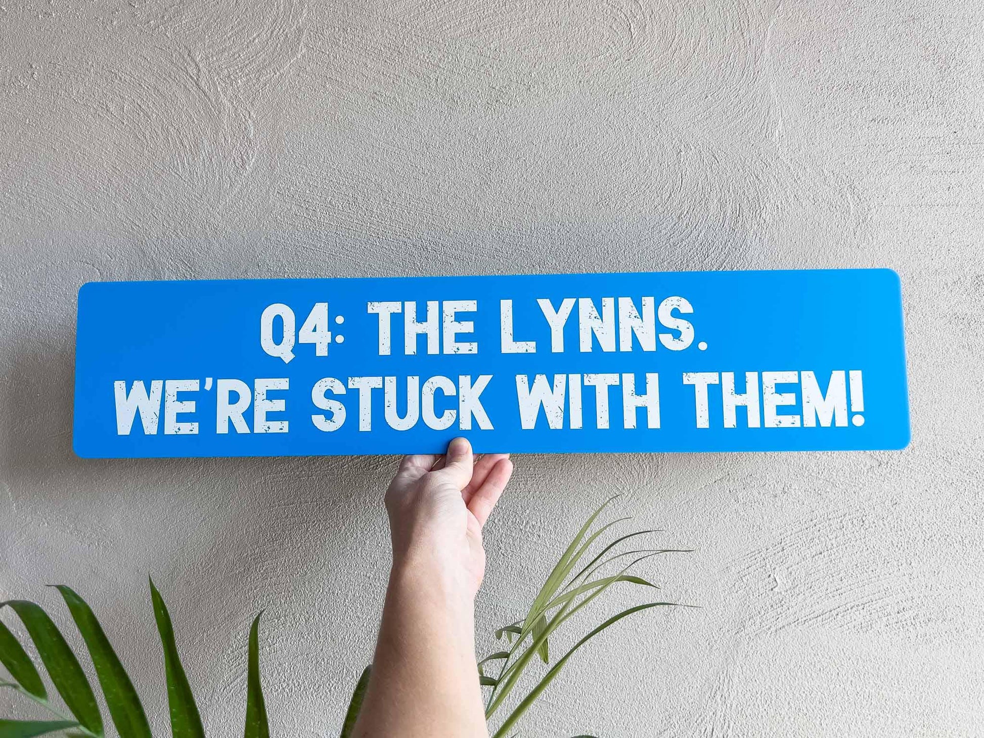 A custom printed blue novety sign panel with white printed text.
