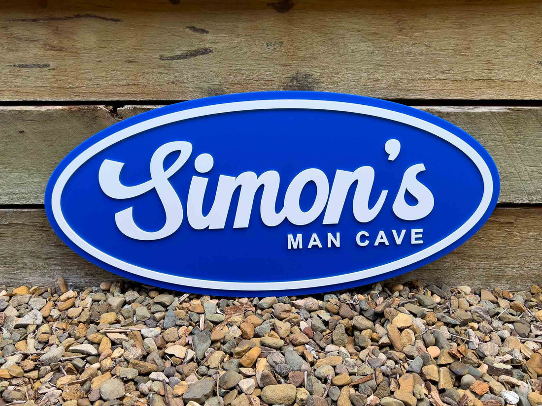 Blue oval badge sign with 'Simon's Man Cave' text on a wooden background