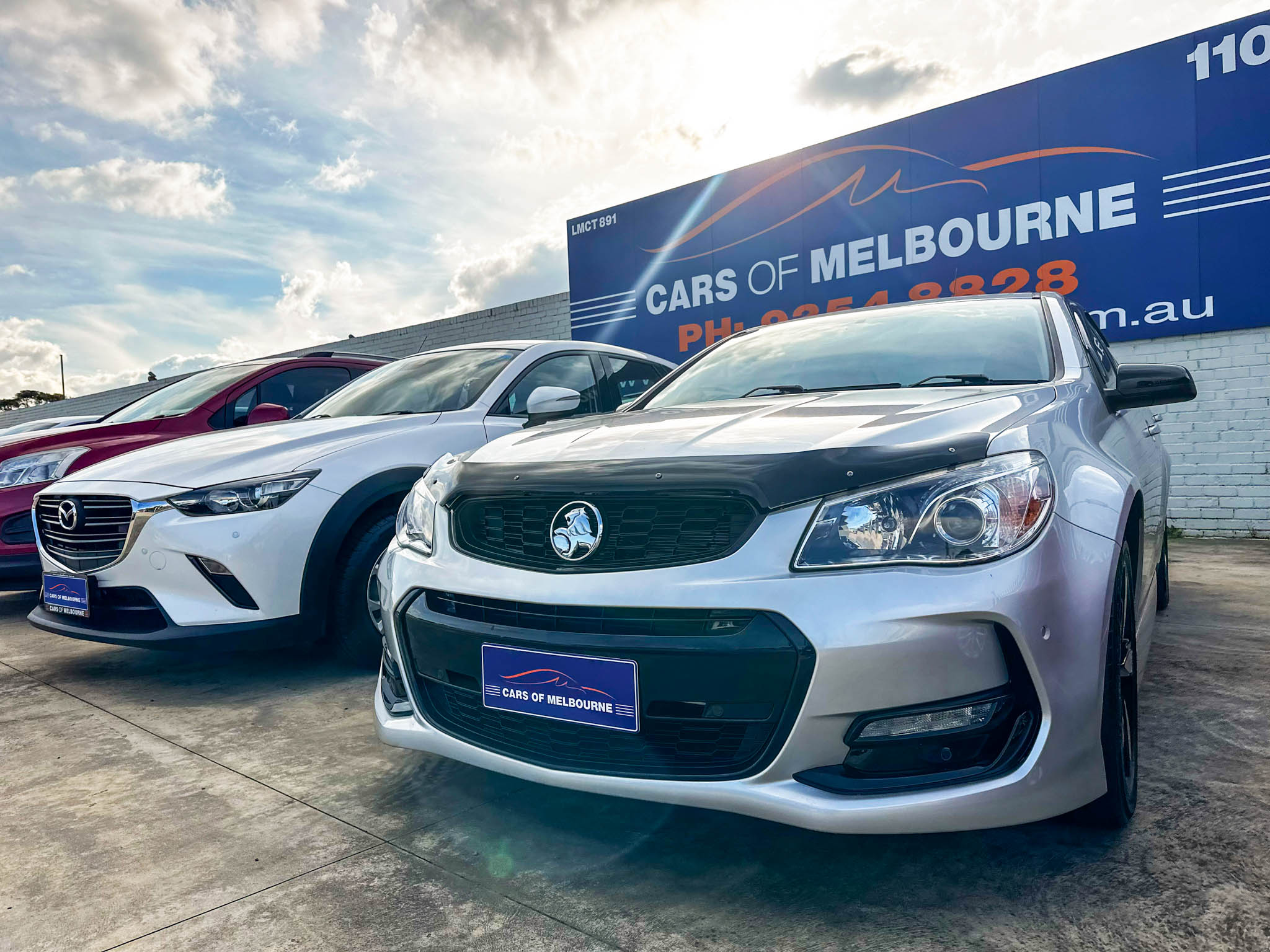 Car yard with cars displaying custom acrylic plates for Cars of Melbourne
