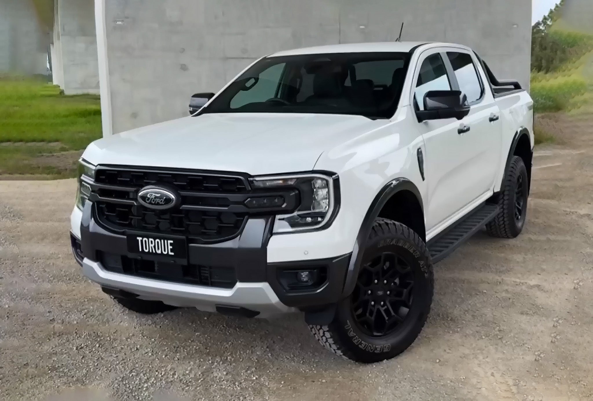 White Ford truck displaying a custom printed TORQUE cover plate.