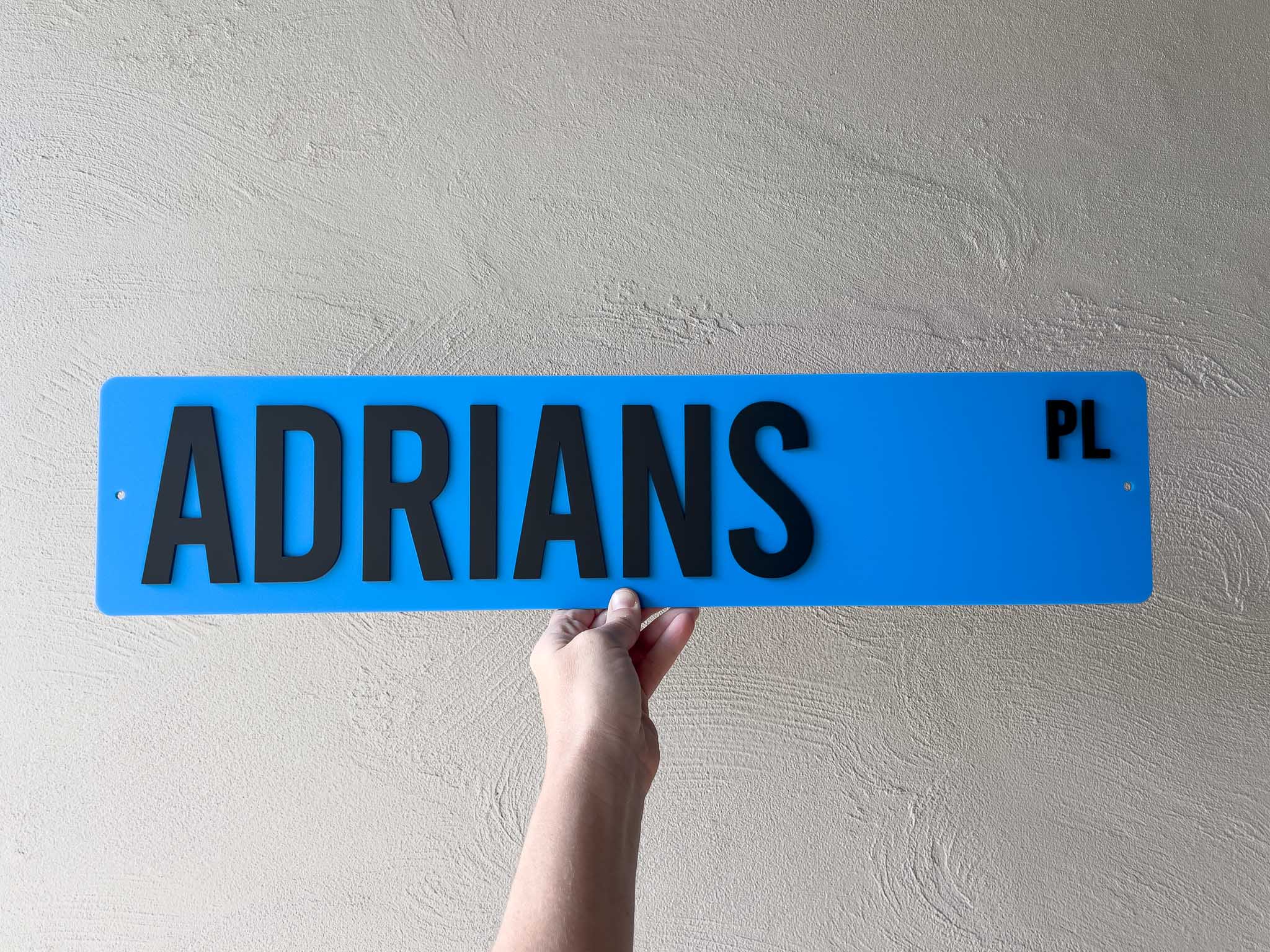 Custom made 3D acrylic sign in coastal blue that reads 'ADRIANS PL' in black text