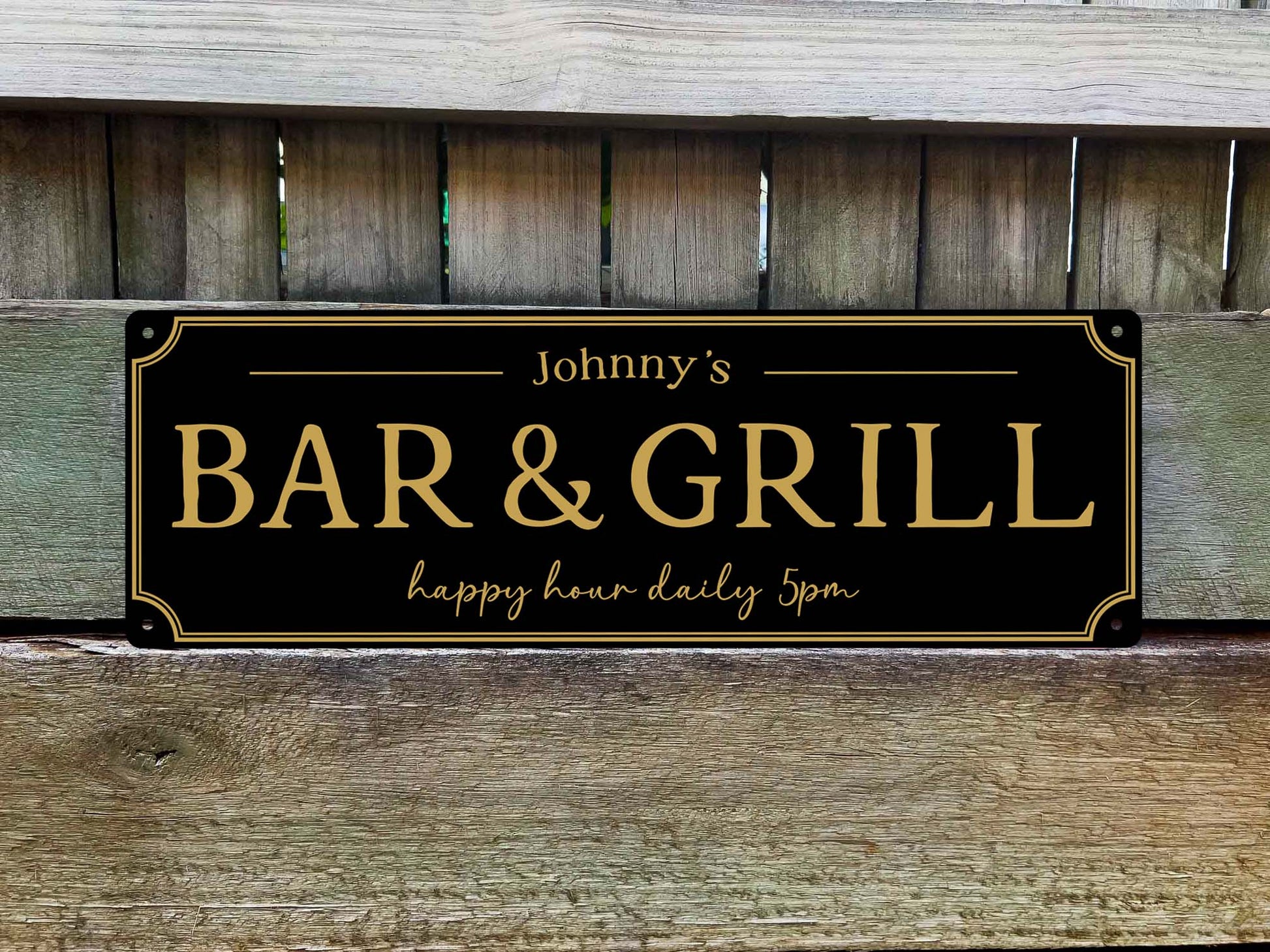 A custom printed black and gold 'Bar & Grill' sign personalised with a name and slogan.