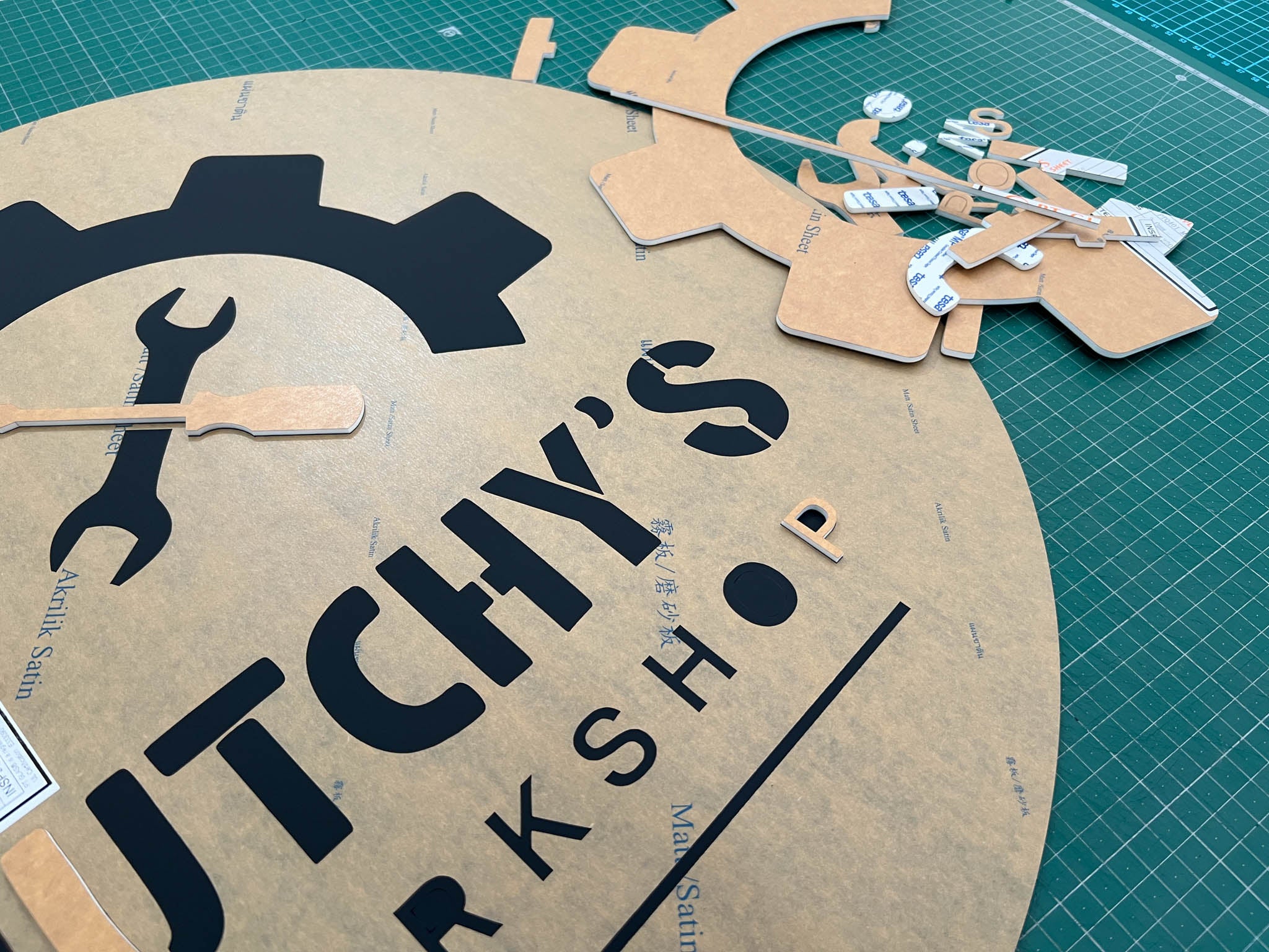 A Kingswood workshop sign being assembled on a bench