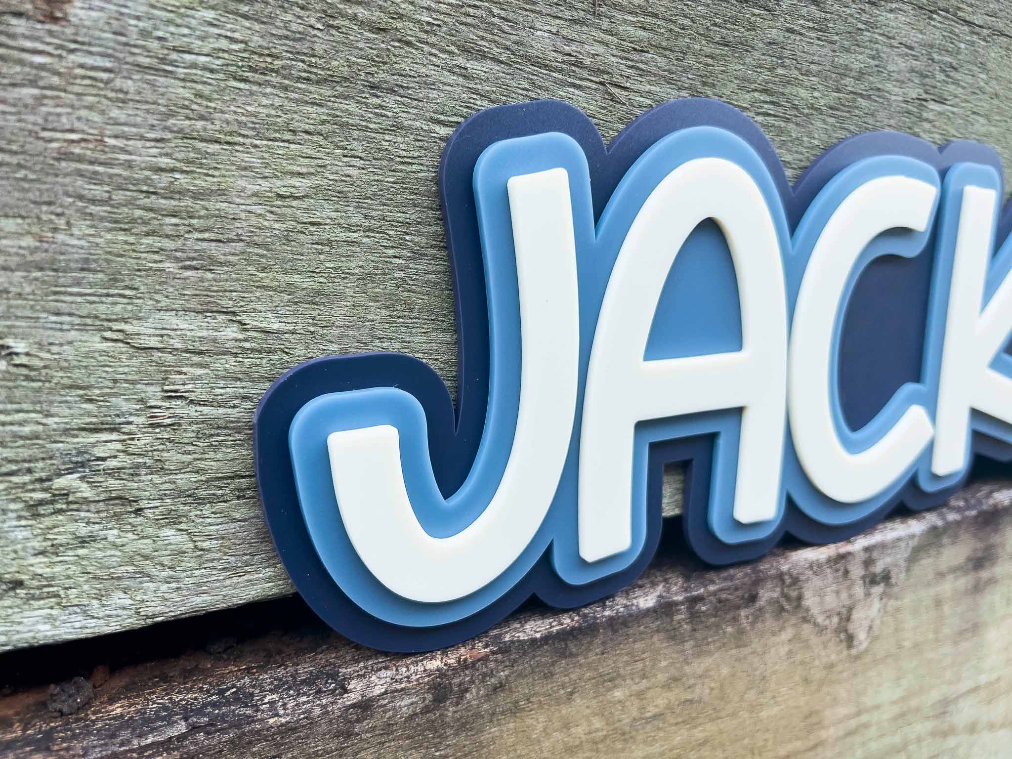 3D lettering spelling 'JACK' on a wooden background