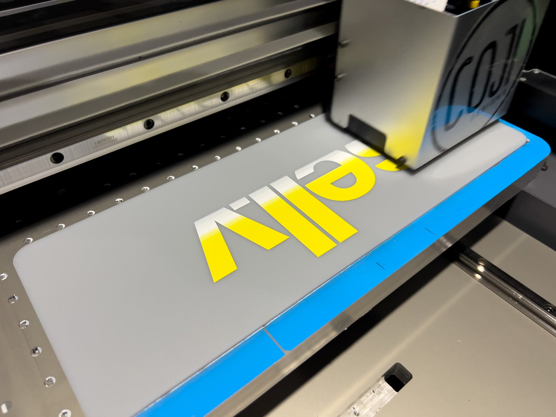 A custom Lancaster logo plate being printed onto a matte grey plate