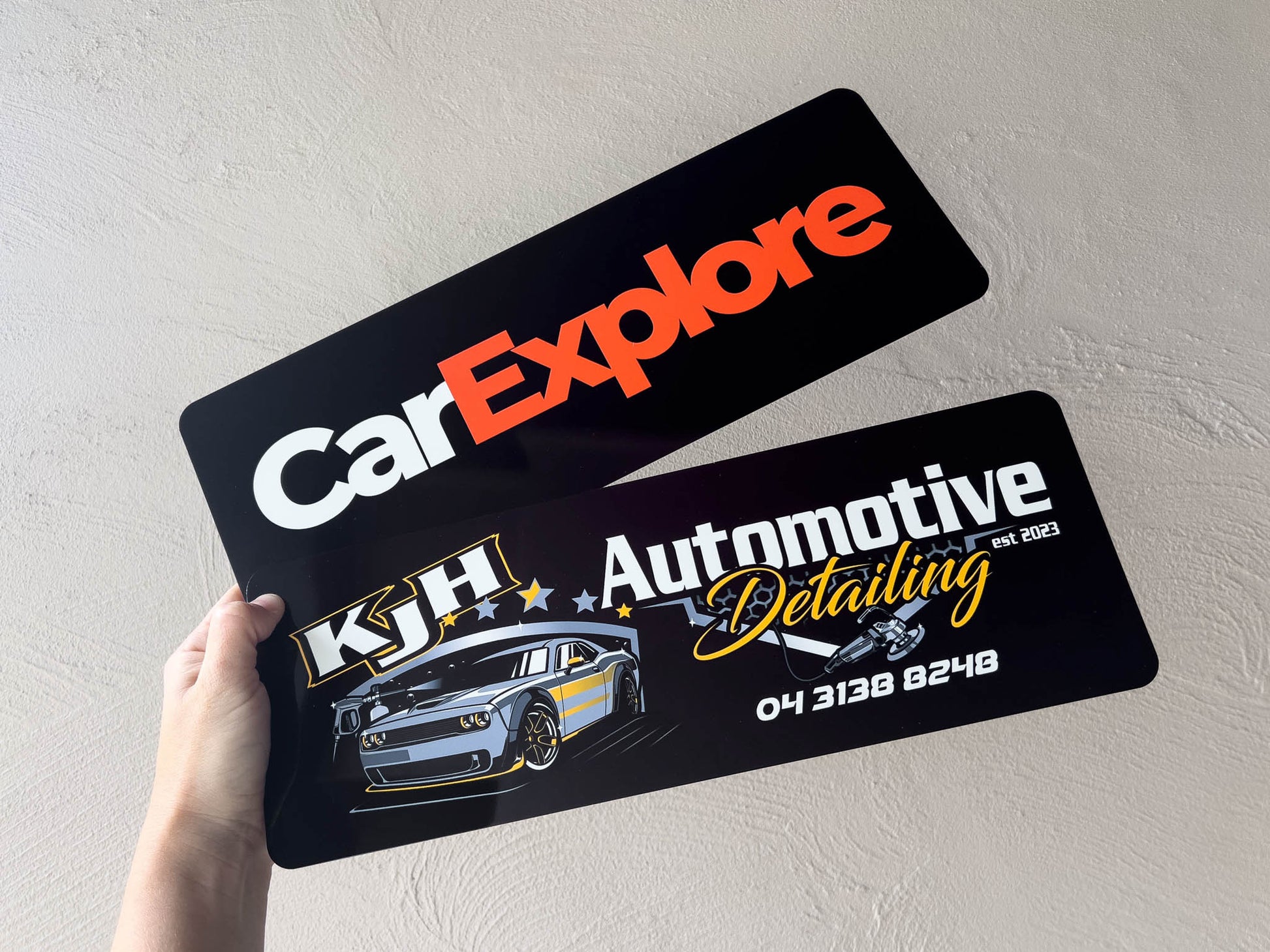 Two branded vehicle logo plates for business promotion.
