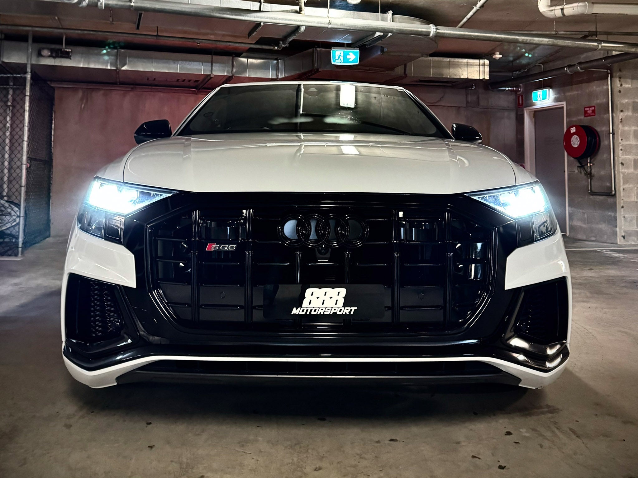 Front view of a white Audi car displaying a 888 Motorsport custom logo plate.