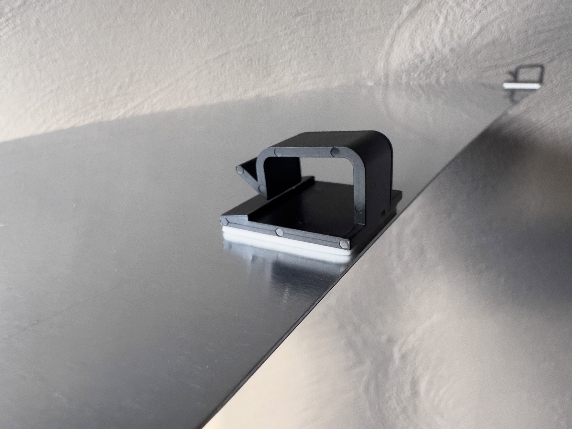Close up view of mounting clips attached to an aluminium plate.
