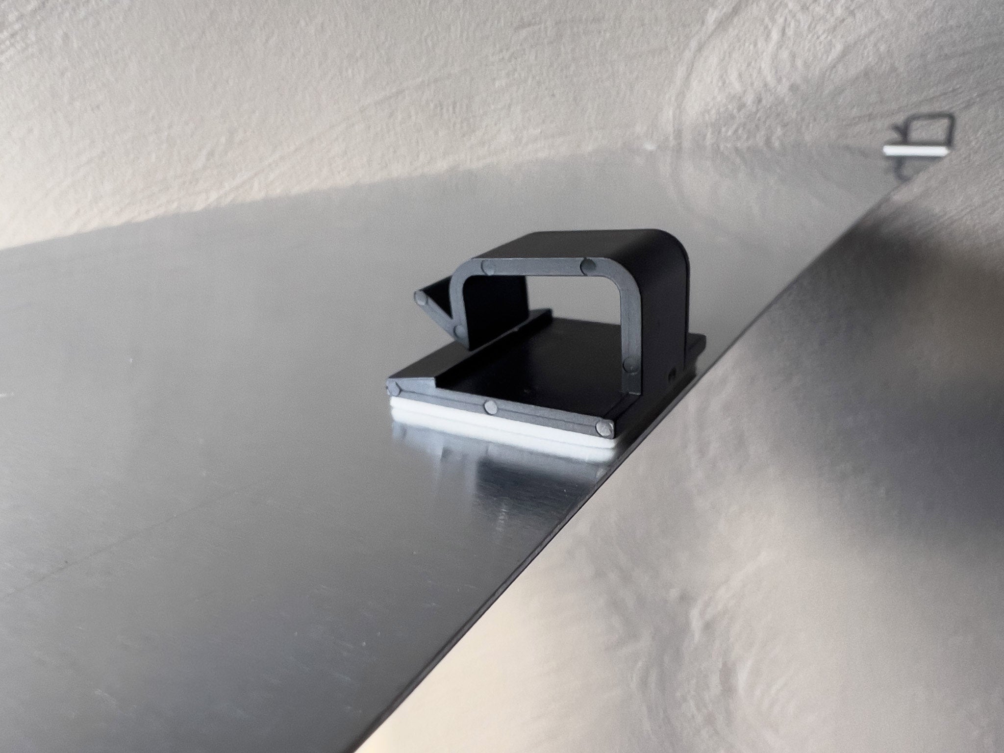 Close up view of mounting clips attached to an aluminium plate.