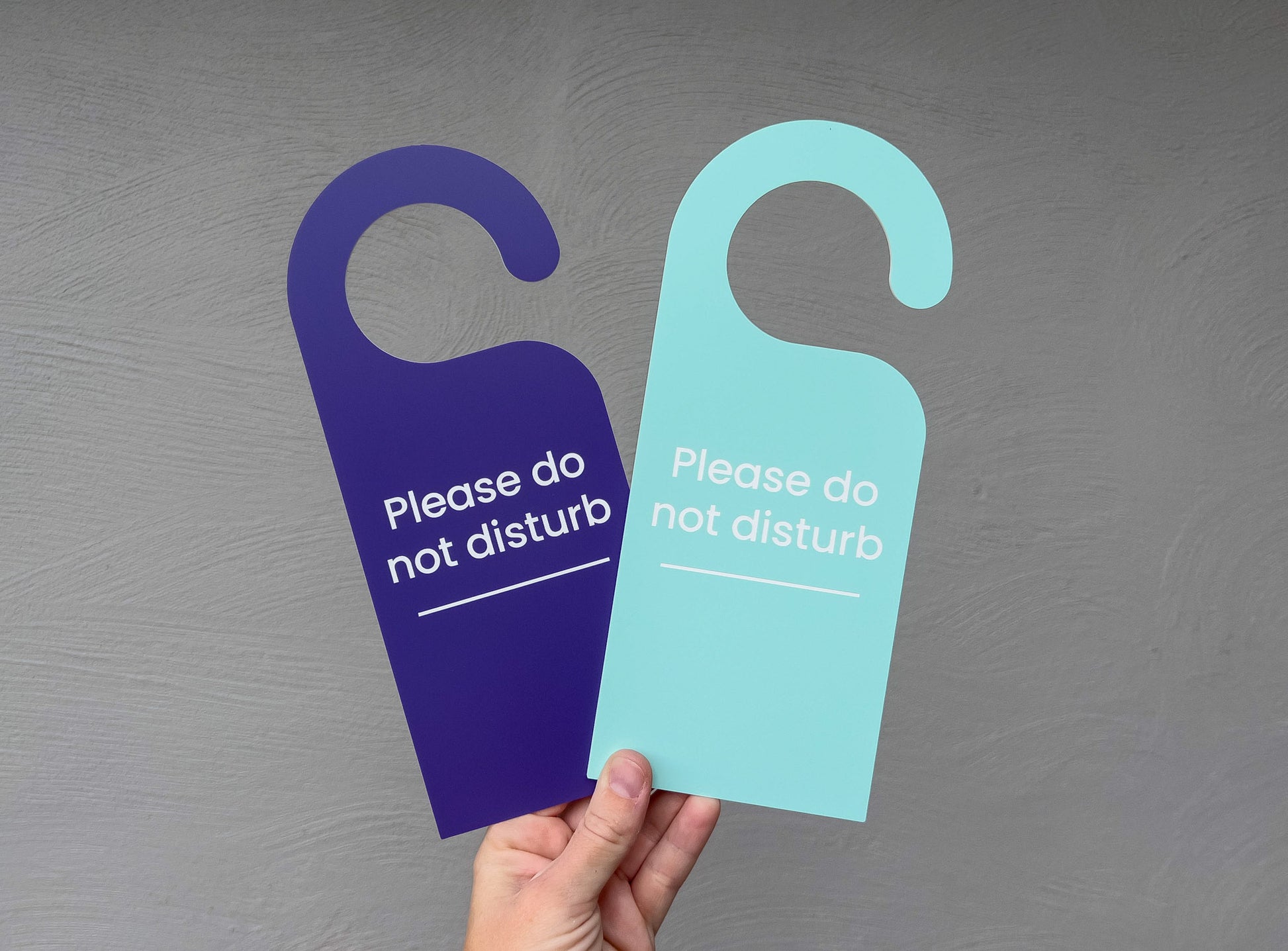 Two personalised laser engraved custom acrylic semi-flexible door hangers that read 'Please do not disturb'.