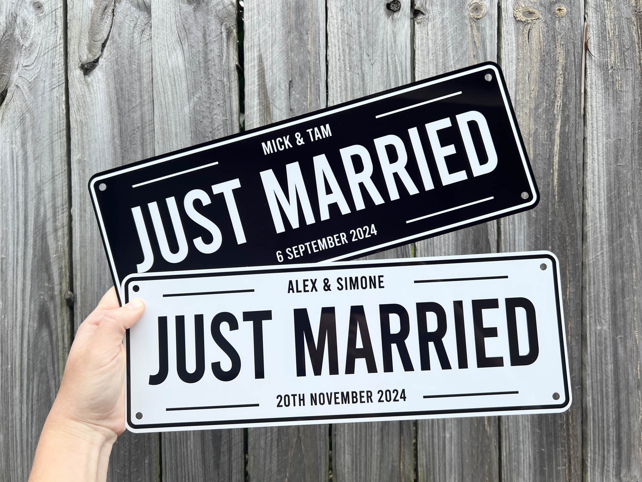 Two 'Just Married' signs held against a wooden background | Coji Designs