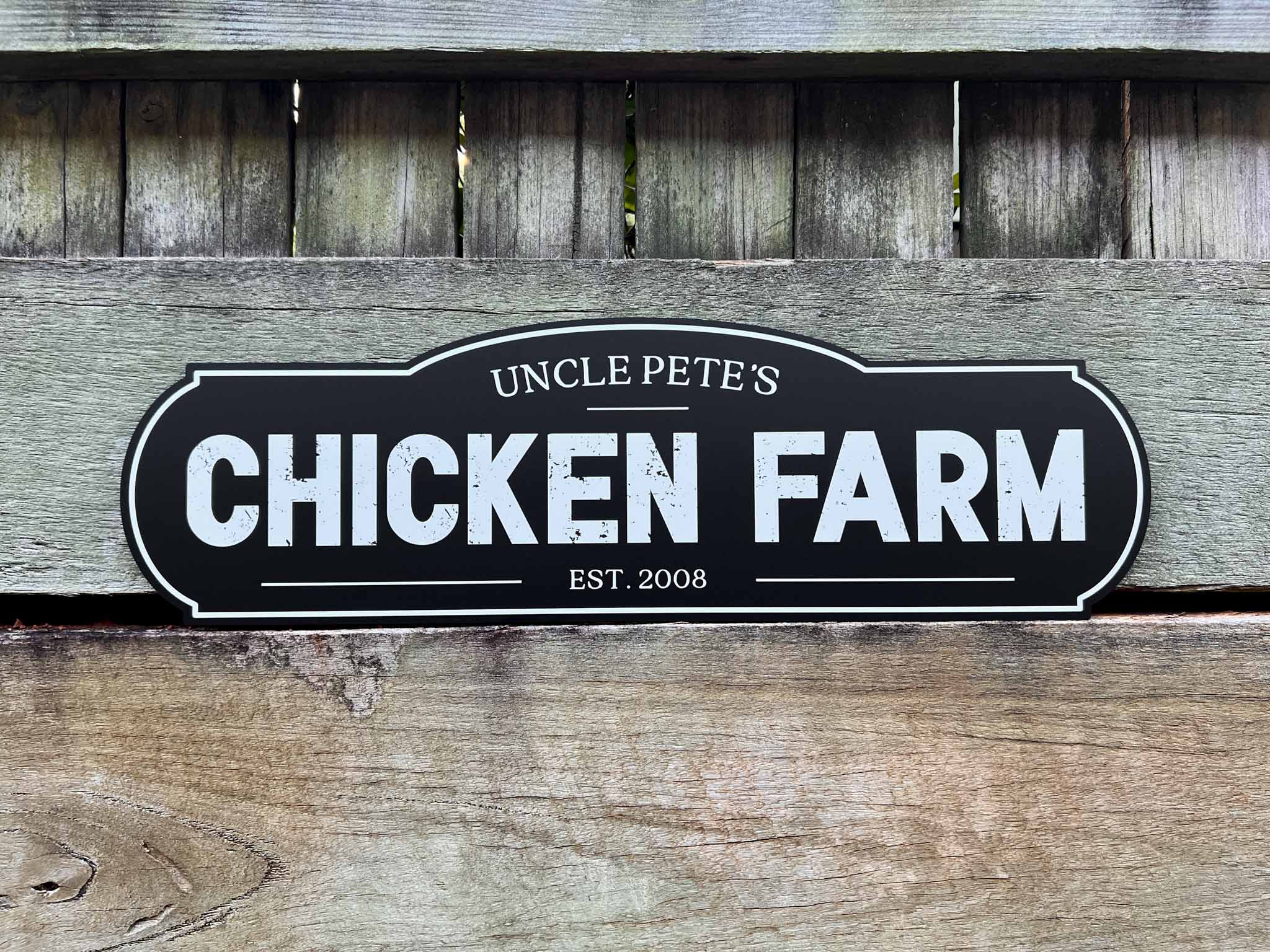 Personalised rustic style homestead rough text black and white sign that says 'Uncle Pete's Chicken Farm'.